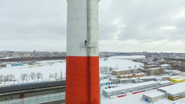 Mannen på skorstenen marken mot anläggning täckt med snö — Stockvideo