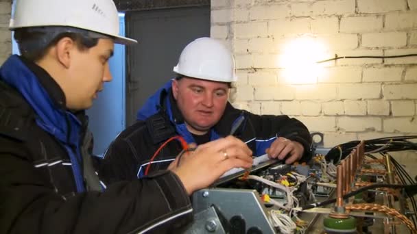 Funcionários trabalham com equipamentos elétricos usando ferramenta — Vídeo de Stock