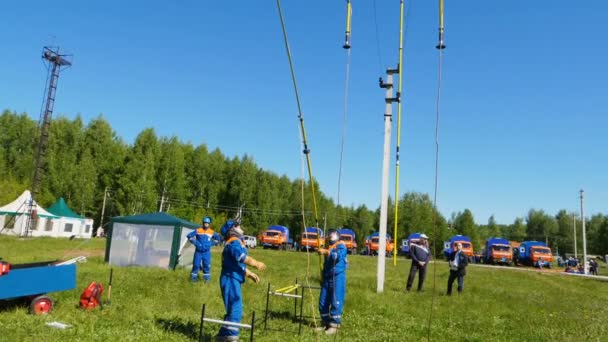 Personas conectan equipos con cables eléctricos en el campo de entrenamiento — Vídeos de Stock