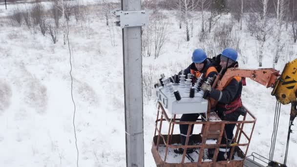 Eletricistas levantar no caminhão guindaste plataforma no dia de inverno — Vídeo de Stock