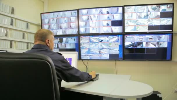 Sicherheitsbeauftragter in der Leitstelle mit Monitoren — Stockvideo