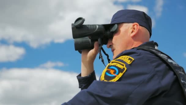 Water patrol officer met verrekijker zeilen op boot — Stockvideo