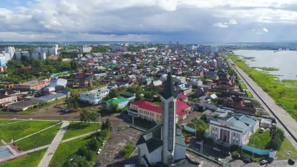 Církevní budova s věží mezi město na břehu jezera — Stock video