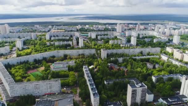 Современный город с зелеными районами против облачного неба — стоковое видео