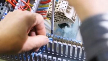 Tatlı adam elektrikçi mavi teller bağlanır ve modern anahtar kartı üzerinde tornavida ile vida katlanmış