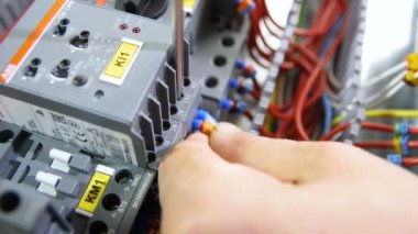 Anahtar kartı üzerinde gri plastik kasa için vida ile mavi izole kablosu closeup elektrikçi el bağlanır