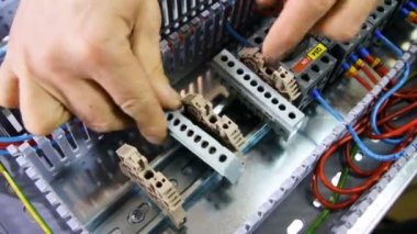 Tatlı adam elektrikçi eller tarafından plastik destek parçaları büyük iletim anahtar kartı atölye üzerinde giderir