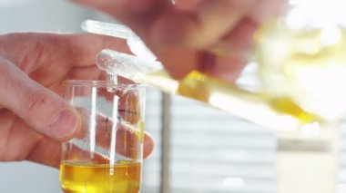 Laboratuar asistanı tarafından bitki laboratuvar küçük cam içine dökülür katkıları üzerinden closeup ham petrol distile