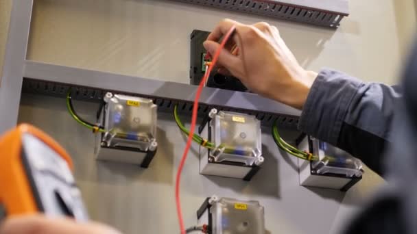 Elektryk mierzy bieżącą za pomocą połączonych miernik elektryczny — Wideo stockowe