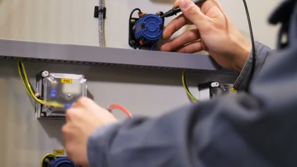 Eletricista se conecta a resistores usando ferramenta especial para medir a tensão — Vídeo de Stock