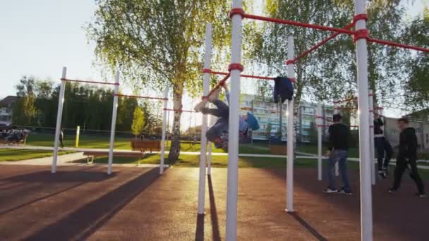 Chlapci a chlapi cvičit na hrazdě na městské sportoviště — Stock video