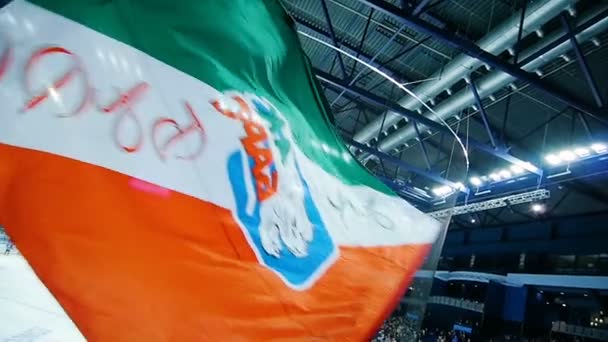 Slowmotion viftande flagga med team logo barer på ice arena — Stockvideo