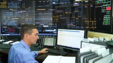 monitör duvar ekranlarda düzenleri ile kontrol merkezinde mühendis çalışıyor
