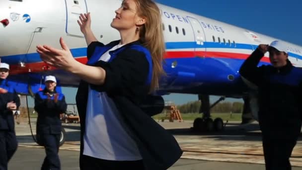 Jolie fille danse sourit et se sent timide par des collègues sur l'aérodrome — Video