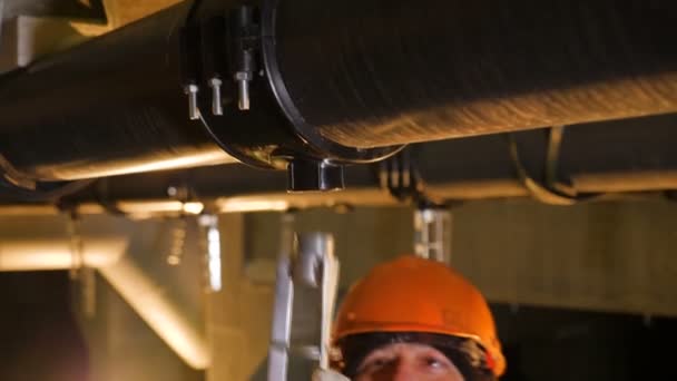 Technicus installeert metalen deel onder gasleiding — Stockvideo