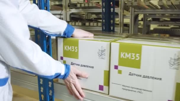 Trabajador pone caja con sensor de movimiento en estante de almacenamiento — Vídeos de Stock