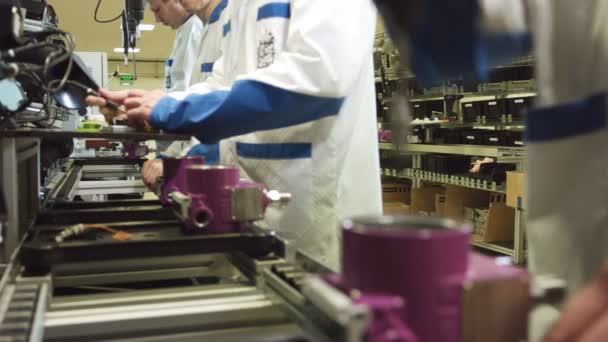 Werknemer wendingen schroef in detail roze behuizing in fabriek — Stockvideo