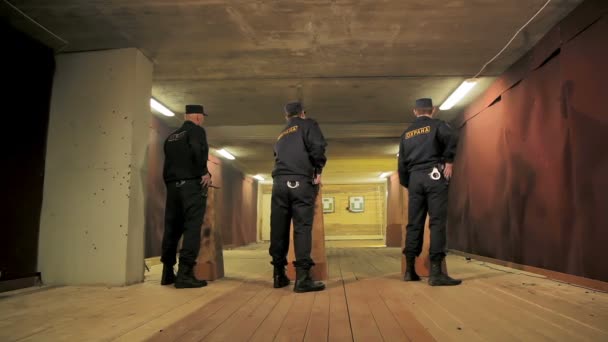 Охранники достают пистолеты из карманов, чтобы стрелять в тире. — стоковое видео