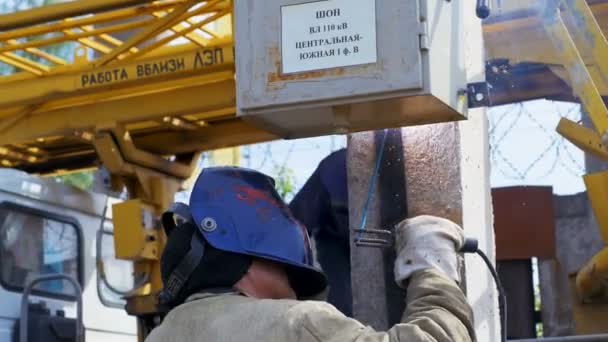 Arbeiter schweißt Schaltschrank an Mast auf Baustelle zusammen — Stockvideo