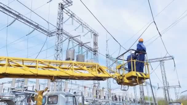 Elettricisti sollevare in appeso gru culla alle linee elettriche — Video Stock