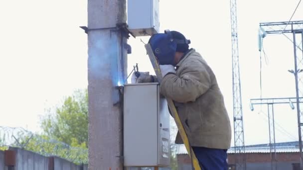 Pracownik rozwiązuje switchboard z urządzenia spawalnicze do bieguna — Wideo stockowe