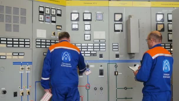 Engenheiros estão em armários de energia de rede controlando leituras — Vídeo de Stock