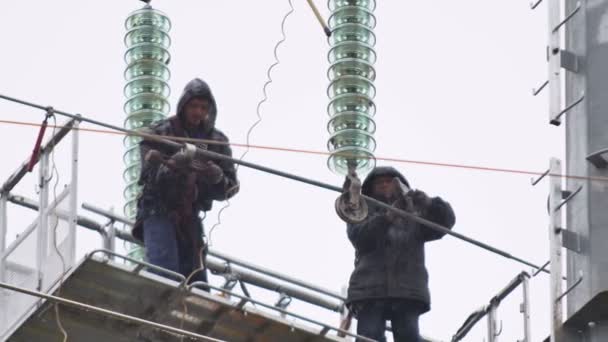 Les ajusteurs fixent l'équipement isolant sur la ligne électrique à haute tension — Video