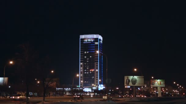 Tráfico de lapso de tiempo en la calle de la ciudad con vallas publicitarias de rascacielos por la noche — Vídeo de stock