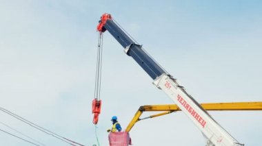 Otomatik vinç direği elektrik kabloları ile yükler.