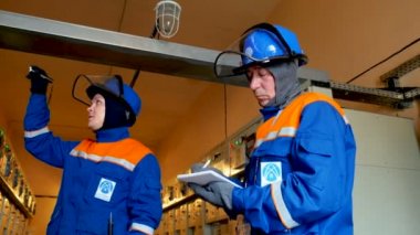 çalışan Müfettiş belgelerle elektrikli cihazlar hakkında söyler.