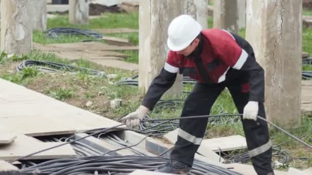 L'employé déroule le fil sur le site de la sous-station électrique — Video