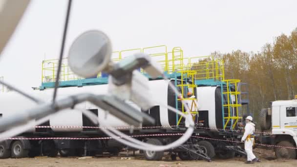 Industriální lampa zvláštní formy proti tanku s chemikáliemi a zaměstnanci — Stock video