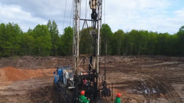 Exploratory drilling machine lifts up pipe to drill on prospecting site — Stock Video