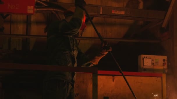 Trabalhador mistura metal fundido com pá especial na planta — Vídeo de Stock