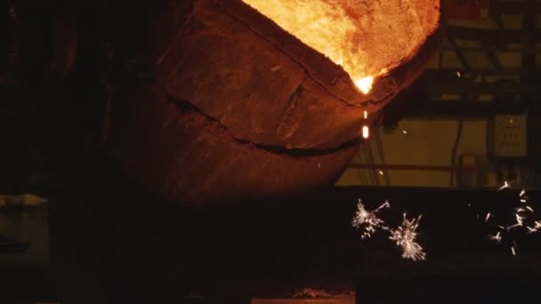 Работник вырывает металл из ведра с искрами — стоковое видео