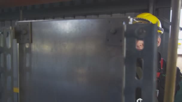 Mitarbeiter mit Helmbrille blickt auf Bedienfeld gegen Ausrüstung — Stockvideo