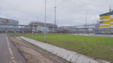 Kazan, Tataristan Rusya - 4 Nisan 2018: Hareket Tatneft logo 4 Nisan tarihinde gri gökyüzü altında petrol depolama tesisine Kazan sanayi için yol kenarındaki binaların geçmiş asfalt yol boyunca