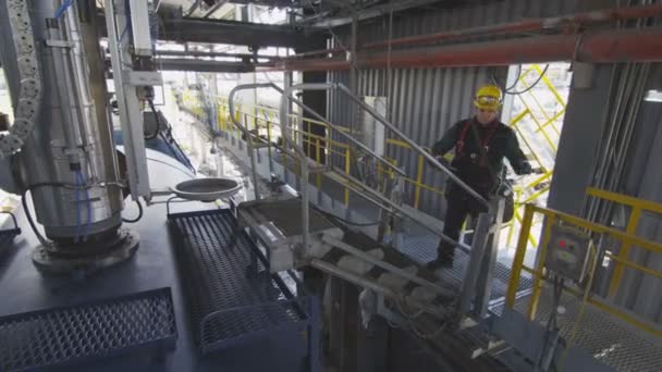 Werknemer verlaagt Opvouwbare brug over pijpen uitrusting voor controles — Stockvideo