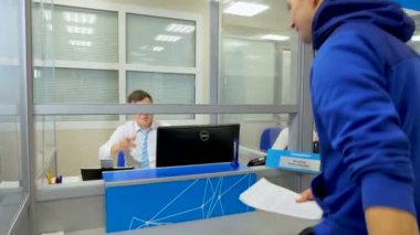 Ziyaretçi Müşteri Merkezi cam arkasında işyerinde çalışan konuşuyor