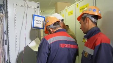 Kazan, Tataristan Rusya - 30 Mayıs 2018: Yan görünümü teknisyenleri şirket logosu ve belgeler ile üniformalı üzerinde 30 Mayıs kazan sorun ağ güç dolapları yakınındaki tartışmak