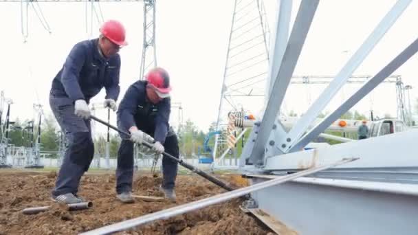 Trabalhadores apertar grande parafuso com ferramenta em feixe de metal no local de construção — Vídeo de Stock