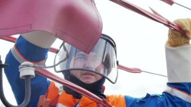 elektrikçi kask ve lastik eldiven araçları ile tel voltaj hatta bağlar.