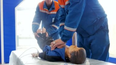 kalp masajı ve suni solunum manken üzerinde üniformalı erkekler yapar