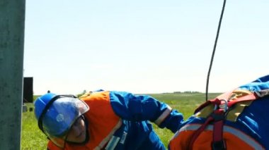 İşçiler metal bacak-ütüler yeşil çayır arasında mavi gökyüzü altında düzeltmek.