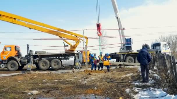 Electric transmission post installed by workers on winter day — Stock Video