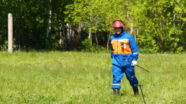 Concurrent avec logo et numéro sur le dos court à travers le champ d'herbe verte avec bâton — Video