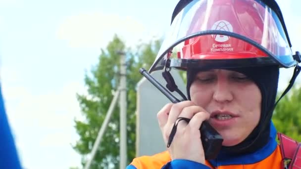 Homem no capacete com escudo de vidro fala através de rádio portátil na competição — Vídeo de Stock