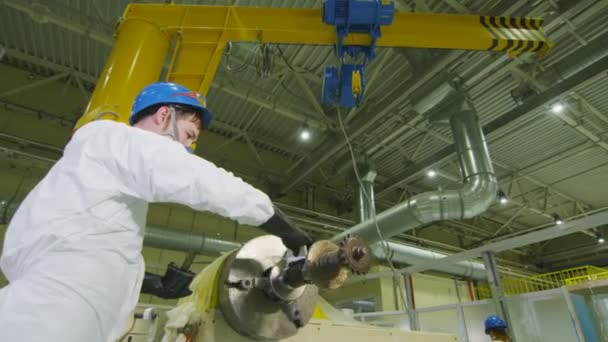 Il dipendente rimuove la lubrificazione extra dall'albero rotante della macchina in fabbrica — Video Stock