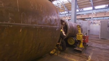 Orta yaşlı kaynakçı sparks altında büyük tüp ile çalışma için hareket