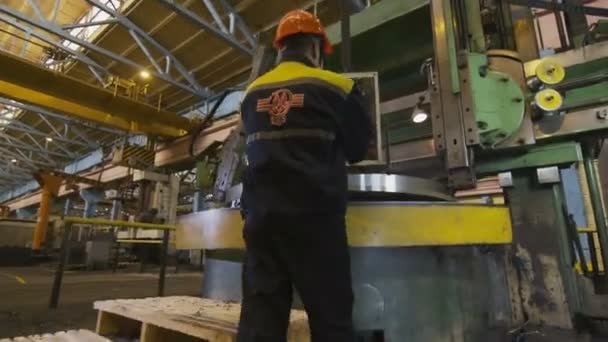 Lavoratore in stivali di gomma arriva fino al pannello di controllo della macchina di tornitura — Video Stock